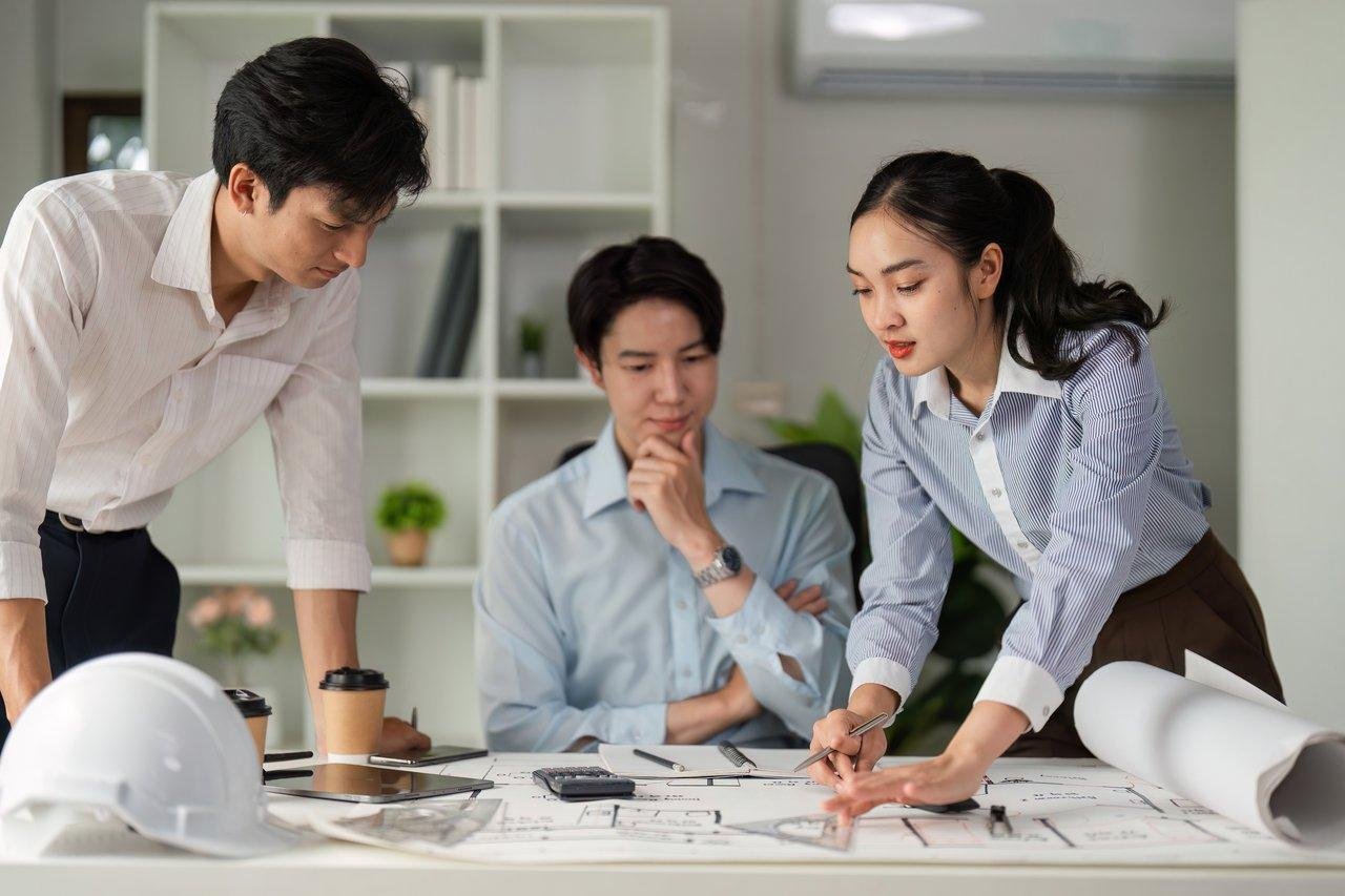 Une réunion d’un interior designer avec un client, plan et échantillons de matériaux pour optimiser la décoration intérieure.